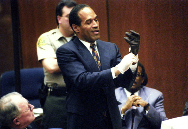Murder defendant O.J. Simpson tries on one of the leather gloves that prosecutors say he wore