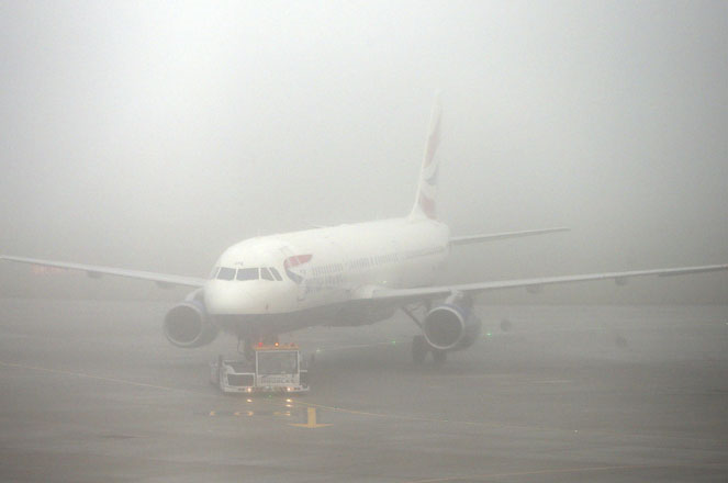 A British Airways plane seen through fog at Terminal 5 Heathrow Airport, London, England, as thick fog disrupts flights at many UK airports for a second day, Monday Nov. 2, 2015. Around 45 flights have been canceled from Heathrow Airport as a yellow weather warning for fog covers much of England. (Steve Parsons / PA via AP) UNITED KINGDOM OUT - NO SALES - NO ARCHIVES