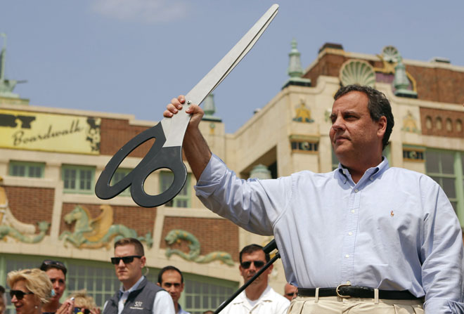 New Jersey Governor Chris Christie (R) holds up a giant pair of scissors after taking part in a ribbon-cutting ceremony during a series of Memorial Day weekend stops along the Jersey shore to mark the start of the summer tourism season, in Asbury Park, New Jersey May 23, 2014. REUTERS/Eduardo Munoz (UNITED STATES - Tags: POLITICS ANNIVERSARY TRAVEL) - RTR3QLWP