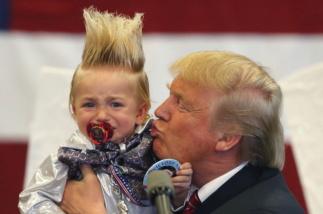 Republican presidential candidate Donald Trump holds up a child he pulled from the crowd as he arrives to speak at a campaign rally in New Orleans, Friday, March 4, 2016. (AP Photo/Gerald Herbert)