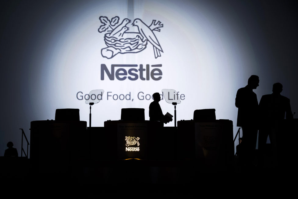 The Nestle SA logo sits on display behind the stage ahead of the company's annual general meeting (AGM) in Lausanne, Switzerland, on Thursday, April 11, 2012. Nestle SA's chairman said Switzerland is becoming more difficult as a business location after voters last month approved some of the world's toughest limits on executives' pay. Photographer: Valentin Flauraud/Bloomberg via Getty Images