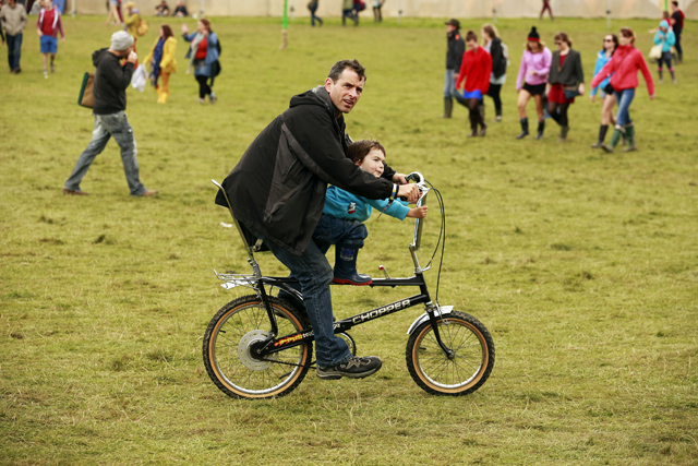 A man cycles with his son near the Little Big tent on the second day of Electric Picnic music festival at Stradbally Hall in County Laois