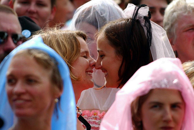 Couples in the crowd during the Midsumma Festival Gay and Lesbian Commitment Ceremony in Melbourne, Australia, Sunday 15 February 2004. Midsumma Festival president Kris Darmody said that as well as expressing love, Summa Vows would be a protest to demand that gays and lesbians be given the same legal rights as heterosexual couples. It was estimated that around 300 couples participated, making it, according to organisers of the event, the world's largest commitment ceremony. (KEYSTONE/EPA/STUART MCEVOY) === AUSTRALIA OUT, NEW ZEALAND OUT ===