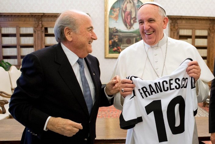 epa03961299 A handout photo released by the Vatican press office shows Pope Francis (C) receiving a gift from FIFA President Sepp Blatter (L) during their meeting at the Vatican on 22 November 2013.  EPA/OSSERVATORE ROMANO / HANDOUT RESTRICTED TO EDITORIAL USE - MANDATORY CREDIT "ANSA / OSSERVATORE ROMANO" - NO MARKETING NO ADVERTISING CAMPAIGNS - DISTRIBUTED AS A SERVICE TO CLIENTS HANDOUT EDITORIAL USE ONLY/NO SALES