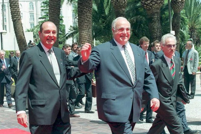 French President Jacques Chirac (L) greets German Chancellor Helmut Kohl at the Palais des Festivals at the opening of the 15 nations European Union Summit in Cannes 26 June. Official at right is unidentified.