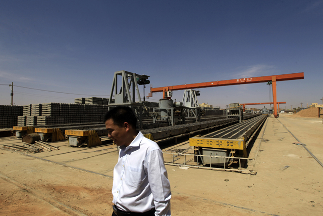 A Chinese man walks at Shanghai Hui Bo Investment Co (SHIC) for manufacturing railway cement sleepers and accessories in north Khartoum February 14, 2013. Sudan should become a transport route for some of South Sudan's oil production once the two countries can agree an arrangement.Work to renew the rail tracks started last year when China's Shanghai Hui Bo Investment Co (SHIC) opened a plant in north Khartoum, opposite the Sudanese capital's main train station, and is producing 1,200 concrete sleepers a day, according to its Sudanese manager Sharaf Nasser. Picture taken February 14, 2013. To match Feature SUDAN-RAILWAY/ REUTERS/Mohamed Nureldin Abdallah (SUDAN - Tags: POLITICS TRANSPORT BUSINESS) - RTR3E106