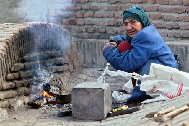 A homeless woman warms herself at the fire on the street in Tbilisi, Saturday, 3 January 2004. The presidential elections are scheduled in Georgia on January 04 and the main candidate Mikhail Saakashvili, one of the leaders of the 'velvet revolution' in Georgia, is expected to win. (KEYSTONE/EPA/SERGEI CHIRIKOV)