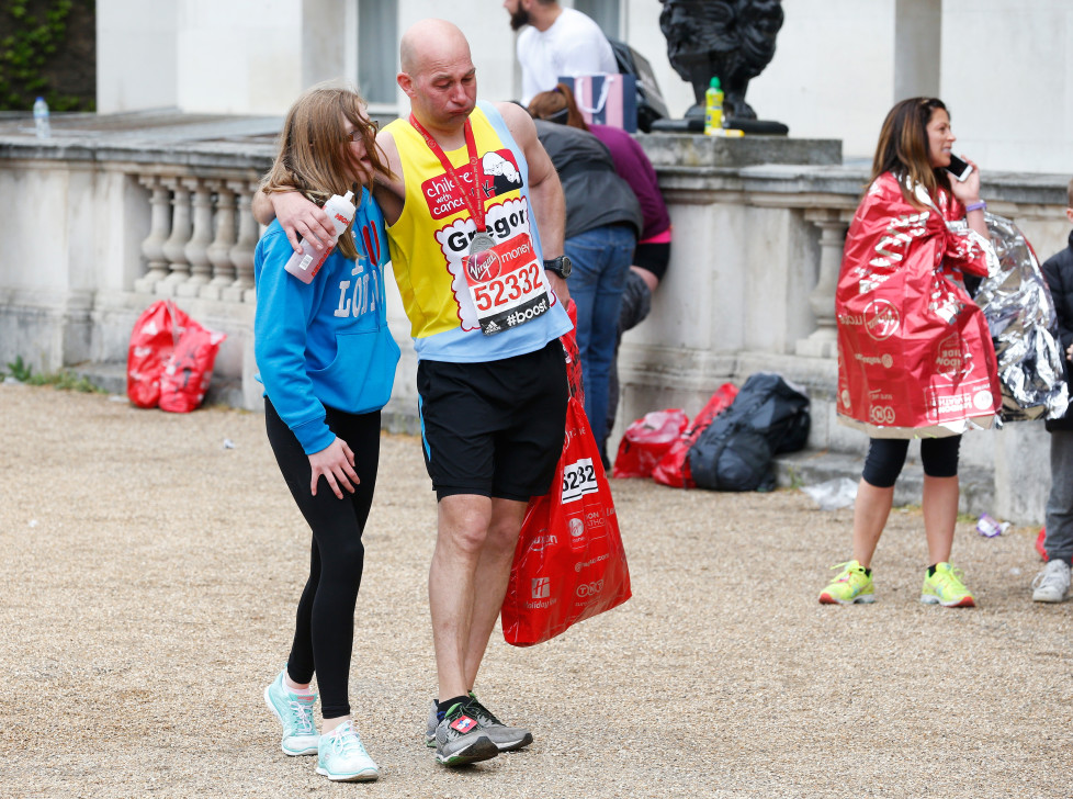 A runner gets a little help after finishing the London Marathon, April 26, 2015. REUTERS/Cathal McNaughton - RTX1AC4P