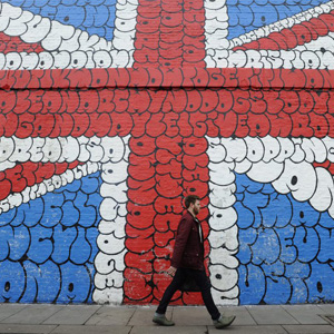 epa03105776 A man walks by a giant graffiti mural depicting the Union Jack in London, Britain, 14 February 2012. Credit ratings agency Moody's has issued official notice to Britain and the Bank of England that their credit ratings are at risk of a potential downgrade. EPA/FACUNDO ARRIZABALAGA