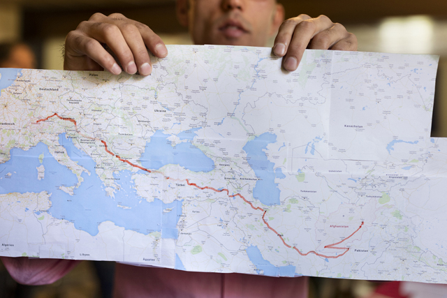 Ein Flüchtling aus Afghanistan zeigt auf einer Karte seinen Weg in die Schweiz. Foto: Gaëtan Bally (Keystone)