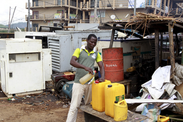 A man seen pouring diesel into a container next to power generators at the Area 10 shopping centre in Abuja, Nigeria May 25, 2015. REUTERS/Afolabi Sotunde - RTX1EGZ8