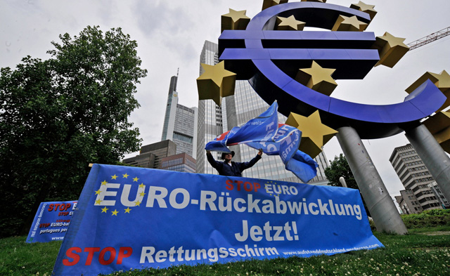 Ein Aktivist demonstriert am Dienstag (21.06.11) vor der Euro-Skulptur vor der Europaeischen Zentralbank in Frankfurt am Main gegen einen Rettungsschirm fuer Griechenland und fuer die "Rueckabwicklung" des Euros.