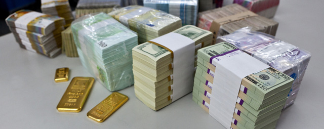 Bundles of bank notes (US dollars, Euros, Swiss francs and British pounds) and gold bars at the bank vault of the "Zuercher Kantonalbank" bank, pictured on August 9, 2011 in Zurich, Switzerland. (KEYSTONE/Martin Ruetschi)