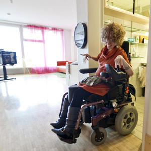 Eine körperlich behinderte Frau in ihrem Zimmer in einem Wohnheim. (Foto: Keystone)