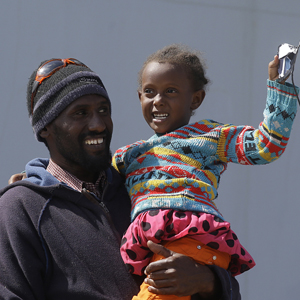 Un réfugié érythréen  avec sa fille après leur arrivée en Sicile.