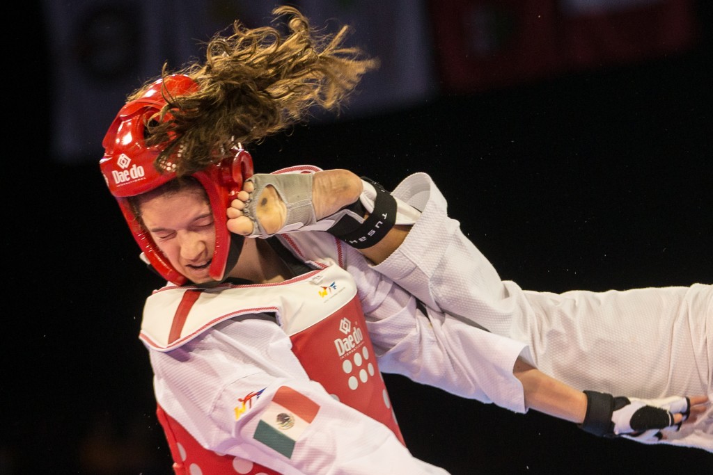 Paulina Armeria of Mexico takes a kick to the head from Cheyenne Lewis of the United States during their gold medal contest in the women's Taekwondo -57kg division of at the 2015 Pan American Games in Toronto, Canada, July 20,  2015.  AFP PHOTO/GEOFF ROBINS
