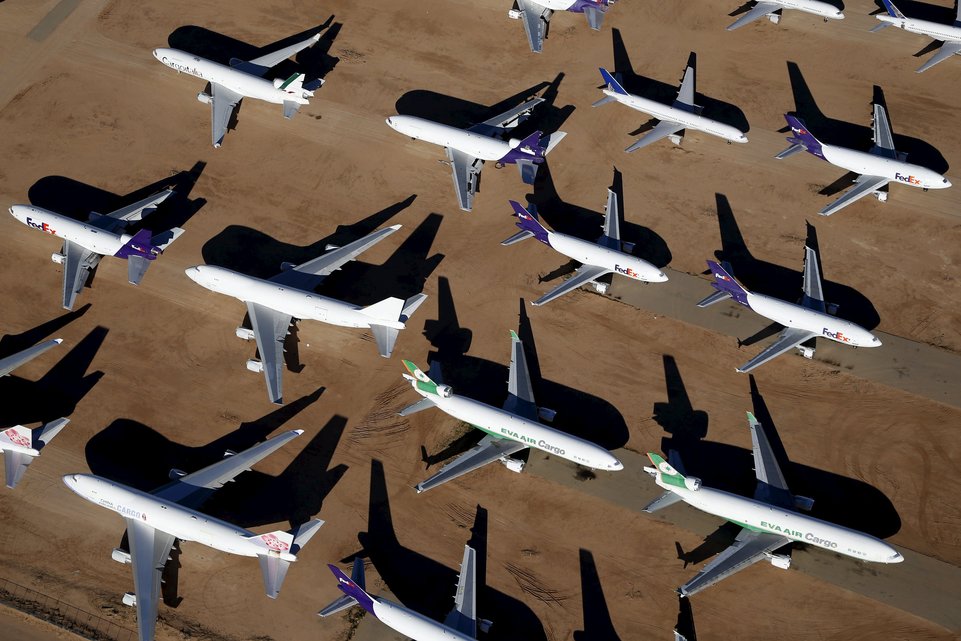 Old airplanes, including Boeing 747-400s, are stored in the desert in Victorville, California March 13, 2015. Last year, there were zero orders placed by commercial airlines for new Boeing 747s or Airbus A380s, reflecting a fundamental shift in the industry toward smaller, twin-engine planes. Smaller planes cost less to fly than the stately, four-engine jumbos, which can carry as many as 525 passengers. Picture taken March 13, 2015. To match Insight AEROSPACE-JUMBO    REUTERS/Lucy Nicholson