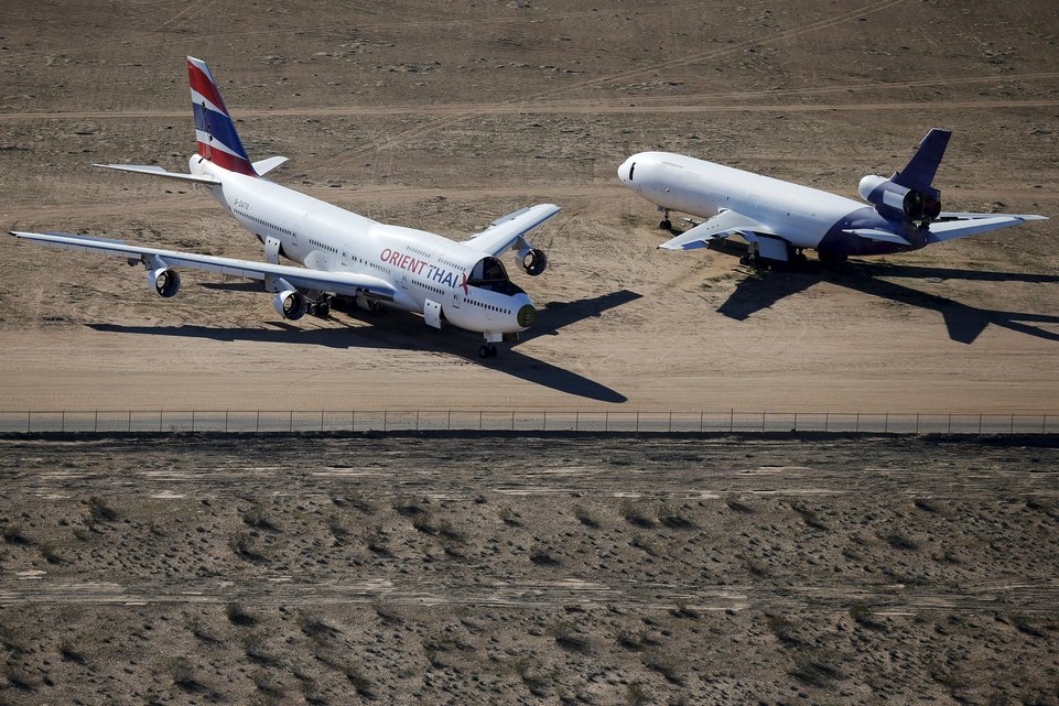 Old airplanes, including an Boeing 747-400, are stored in the desert in Victorville, California March 13, 2015. Last year, there were zero orders placed by commercial airlines for new Boeing 747s or Airbus A380s, reflecting a fundamental shift in the industry toward smaller, twin-engine planes. Smaller planes cost less to fly than the stately, four-engine jumbos, which can carry as many as 525 passengers. Picture taken March 13, 2015. To match Insight AEROSPACE-JUMBO    REUTERS/Lucy Nicholson