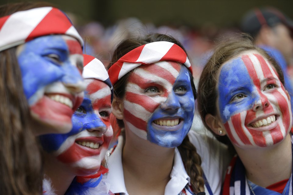 Fans of the United States with painted faces smile in the stands before the FIFA Women's World Cup soccer championship between the U.S. and Japan in Vancouver, British Columbia, Canada, Sunday, July 5, 2015. (AP Photo/Elaine Thompson)