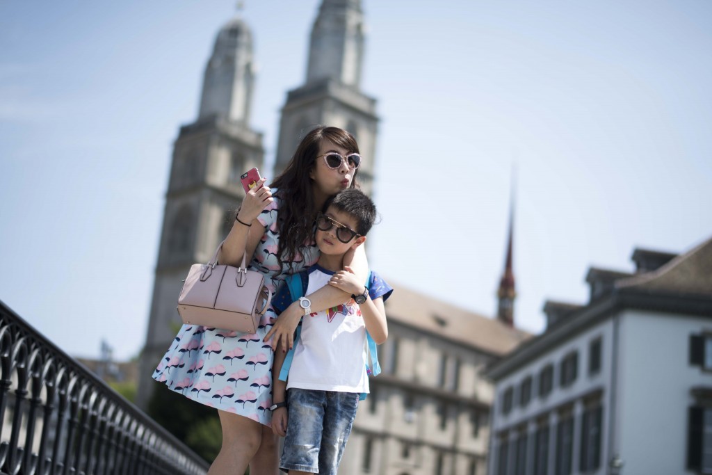 Reportage: Mit einer chinesischen Luxus-Reisegruppe durch Zürich. Fotostop auf der Rathausbrücke mit Grossmünster im Hintergrund.  11.07.2015 (Tages-Anzeiger/Urs Jaudas)