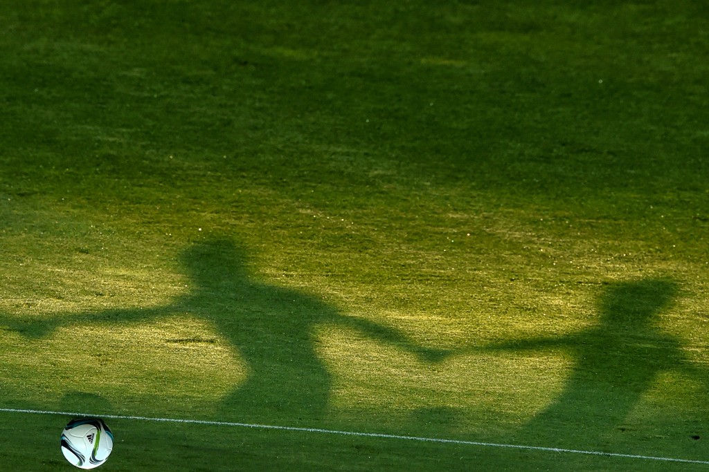 This picture taken on August 10, 2015 at the Boris Paichadze Dinamo Arena in Tbilisi shows shadows of Sevilla FC players as they attend a training session on the eve of the UEFA Super Cup football match between FC Barcelona and Sevilla FC. AFP PHOTO / KIRILL KUDRYAVTSEV
