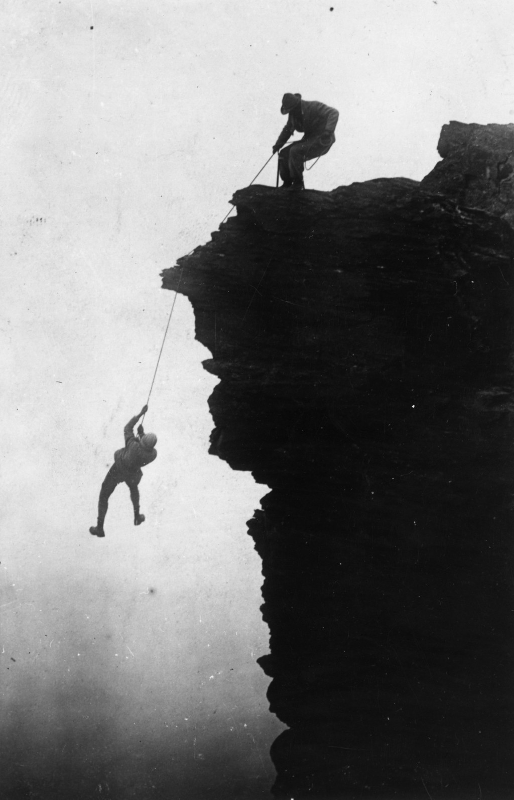 circa 1900:  A rock climber swinging on a rope as he is hauled up a cliff face.  (Photo by Hulton Archive/Getty Images)