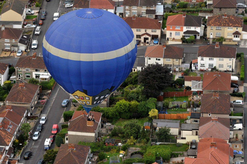 A hot air balloon flies above a residential area of Bristol, south-west England, on August 13, 2010, during a mass assent flight at the 32nd Bristol International Balloon Fiesta in Bristol, south-west England, on August 13, 2010. Weird and wonderful shapes filled the skies as Europe's biggest hot air balloon festival marked the golden jubilee of modern ballooning. More than half a million people were expected to attend the four-day Bristol International Balloon Fiesta, held on a country estate in Bristol, southwest England. AFP PHOTO/BEN STANSALL