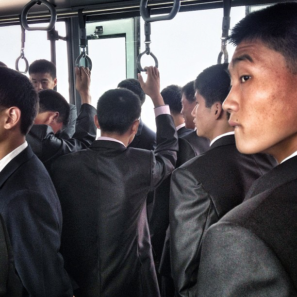 North Korean men on an airport transport bus headed to the Air Koryo flight for Beijing. (AP Photo/David Guttenfelder)