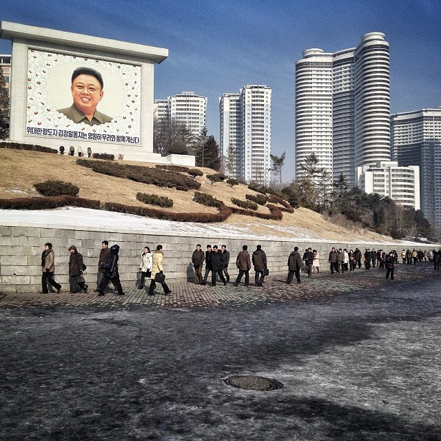 Residents of Pyongyang walk by a mosaic of the late leader Kim Jong Il in the 2nd anniversary if his death. (AP Photo/David Guttenfelder)