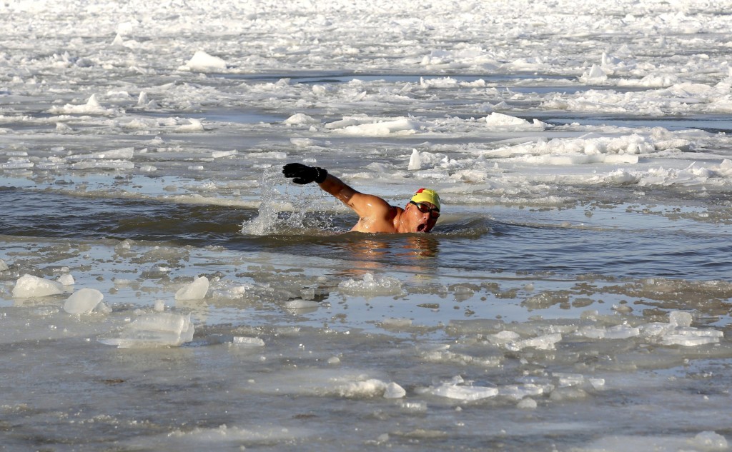 A winter swimmer swims in icy water after breaking part of the frozen surface of the Amur river, in Heihe, Heilongjiang province, China, November 1, 2015. Picture taken November 1, 2015. REUTERS/China Daily CHINA OUT. NO COMMERCIAL OR EDITORIAL SALES IN CHINA