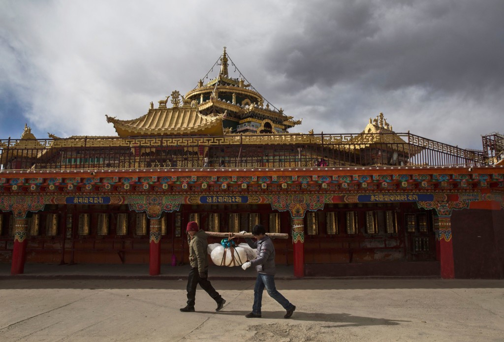 SERTAR, CHINA - OCTOBER 30: Tibetan Buddhists carry the body of a relative as they circumbulate a monastery before sky burial at the Larung Wuming Buddhist Institute on October 30, 2015 in Sertar county, in the remote Garze Tibetan Autonomous Prefecture, Sichuan province, China. The last of four annual assemblies, the week long annual gathering takes place in the ninth month of the Tibetan calendar and marks Buddha's descent from the heavens. Located high in the mountains of Sichuan, the Larung Wuming Buddhist Institute was founded in 1980 by an influential lama of the Nyingma sect and is widely regarded as the world's largest and most influential centres for Tibetan Buddhist studies. The school is home to thousands of monks and nuns and is popular for followers from all over the Tibetan areas and other parts of China. (Photo by Kevin Frayer/Getty Images)