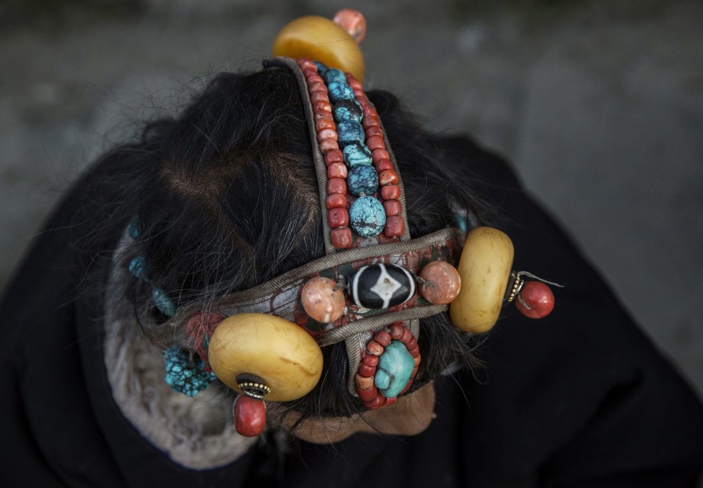 SERTAR, CHINA - NOVEMBER 1: A Tibetan Buddhist woman wears traditional stones in her hair at the annual Bliss Dharma Assembly at the Larung Wuming Buddhist Institute on November 1, 2015 in Sertar county, in the remote Garze Tibetan Autonomous Prefecture, Sichuan province, China. The last of four annual assemblies, the week long annual gathering takes place in the ninth month of the Tibetan calendar and marks Buddha's descent from the heavens. Located high in the mountains of Sichuan, the Larung Wuming Buddhist Institute was founded in 1980 by an influential lama of the Nyingma sect and is widely regarded as the world's largest and most influential centres for Tibetan Buddhist studies. The school is home to thousands of monks and nuns and is popular for followers from all over the Tibetan areas and other parts of China. (Photo by Kevin Frayer/Getty Images)