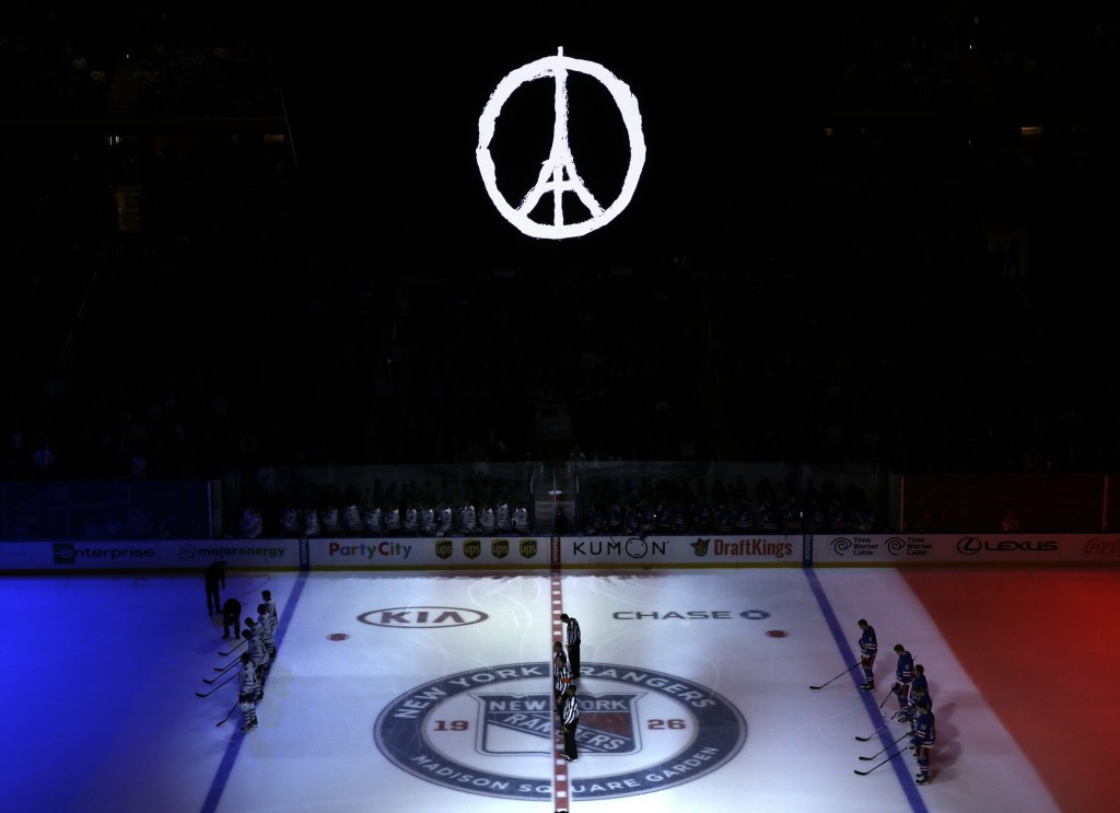 The colors of France's flag are projected onto the ice as the national anthem of France is played before an NHL hockey game between the New York Rangers and the Toronto Maple Leafs, Sunday, Nov. 15, 2015, in New York. Multiple attacks across Paris on Friday night left scores dead and hundreds injured. (AP Photo/Seth Wenig)