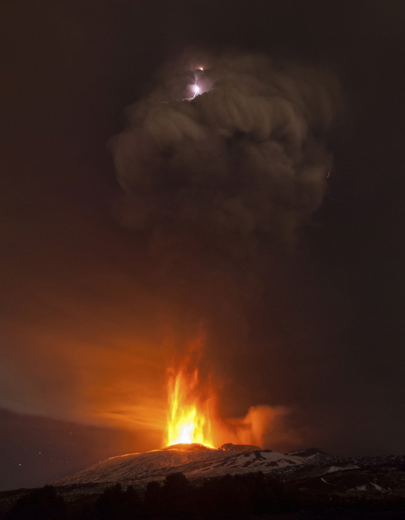 In this picture made available Friday, Dec. 4, 2015, lightning is seen in the cloud of smoke during an eruption of Mt. Etna, near Catania, Italy, Thursday Dec. 3, 2015. Mt. Etna is Europe's most active volcano at 3,350 meters (10,990 feet) and erupts quite frequently. (AP Photo/Salvatore Allegra)