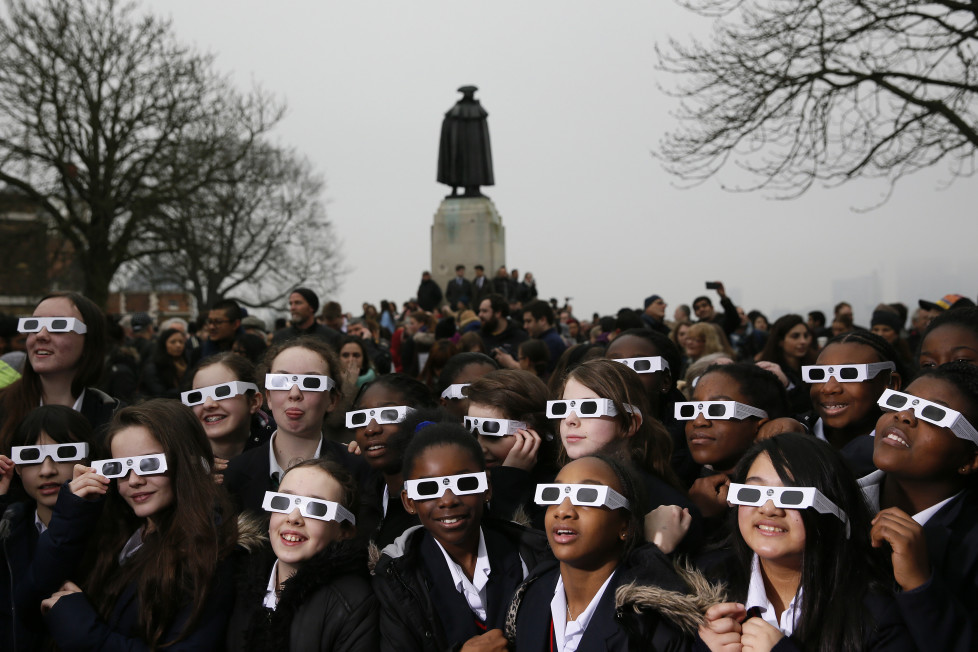 School children wearing protective glasses pose for photographers outside The Royal Observatory during a partial solar eclipse in Greenwich, south east London March 20, 2015. REUTERS/Stefan Wermuth - RTR4U555