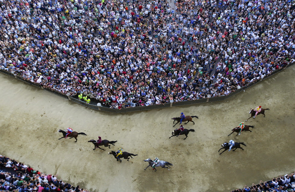 Horses race during the general practice session for the Palio di Siena horse race in Siena, Italy, July 1, 2015. Each July 2 and August 16, almost without fail since the mid-1600s, 10 riders have hurtled bareback around Siena's shell-shaped central square in a desperate bid to win the Palio, a silk banner depicting the Madonna and child. REUTERS/ Max Rossi TPX IMAGES OF THE DAY ATTENTION EDITORS - FOR EDITORIAL USE ONLY. NOT FOR SALE FOR MARKETING OR ADVERTISING CAMPAIGNS. - RTX1INO4