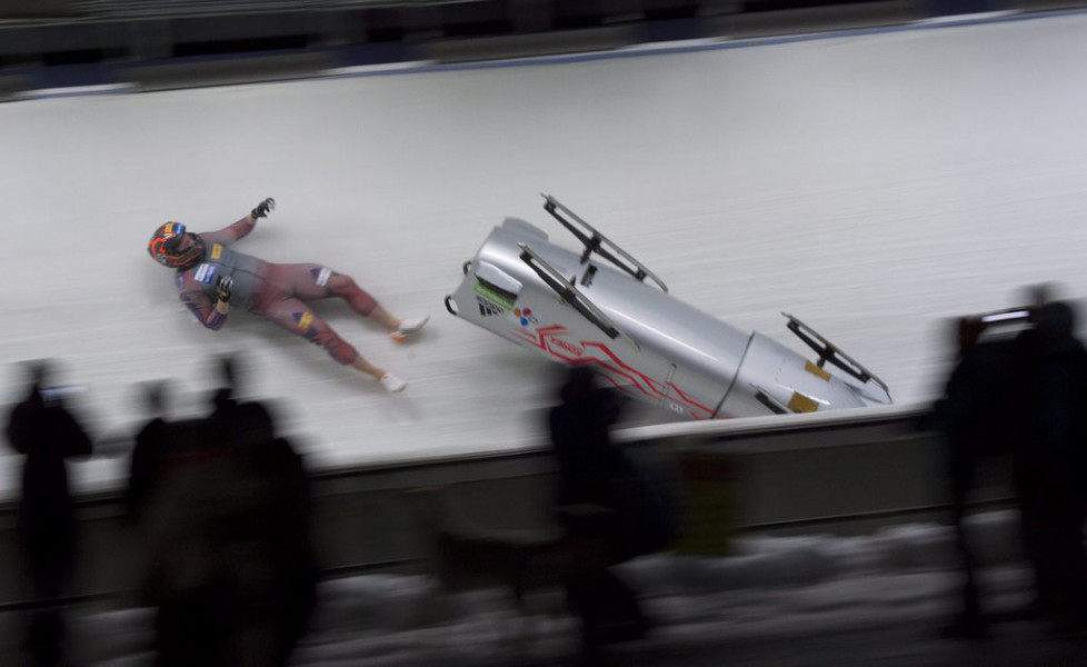 Brakeman Kim Keun-bo, of South Korea, falls out of his sled as he and pilot Kim Dong-hyun race during the second run of the World Cup two-man bobsled in Whistler, British Columbia, Saturday, Jan. 23, 2016. (Jonathan Hayward/The Canadian Press via AP)