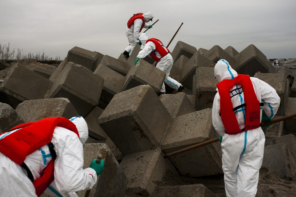 Japan, Namie, 2012. Police search for remains of missing people inside the nuclear exclusion zone near the damaged Daiichi nuclear power plant one year after the Tsunami hit the north east coast of Japan.