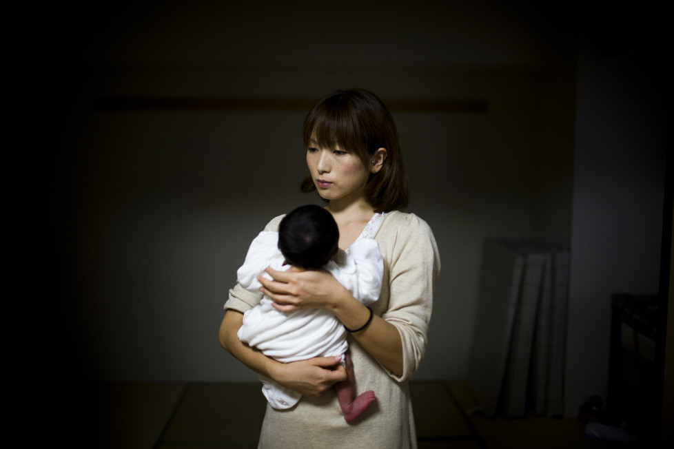 Japan, Tokyo, 2011 Sachiko Masuyama (30) now in her new home in Shinonome housing for government workers. She discovered she was pregnant, two days before the quake and now hold her new born.