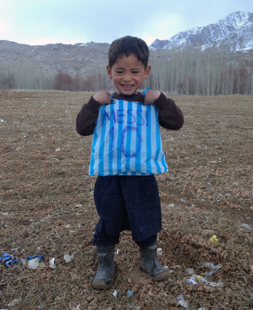 This photograph taken on January 24, 2016 and provided by the family of Afghan boy and Lionel Messi fan Murtaza Ahmadi, 5, with his plastic bag jersey in Jaghori district of Ghazni province. A five-year-old Afghan boy has become an internet star after pictures went viral of him wearing an Argentina football shirt made out of a plastic bag, complete with his hero Lionel Messi's name. AFP PHOTO / AFP / STR