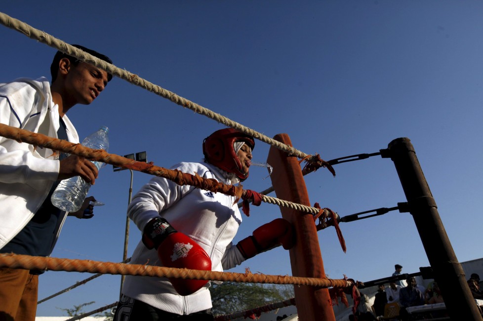 Urooj, 15, spits water between rounds in her bout during the Sindh Junior Sports Association Boxing Tournament in Karachi, Pakistan February 21, 2016. For the past six months about a dozen girls, aged 8 to 17, have gone to the Pak Shine Boxing Club after school to practice their jabs, hooks and upper cuts. Pakistani women have been training as boxers in small numbers and competed in the South Asian Games last year, said Younis Qambrani, the coach who founded the club in 1992 in the Karachi neighbourhood of Lyari, better known for internecine gang warfare than for breaking glass ceilings. REUTERS/Akhtar Soomro SEARCH "THE WIDER IMAGE" FOR ALL STORIES TPX IMAGES OF THE DAY