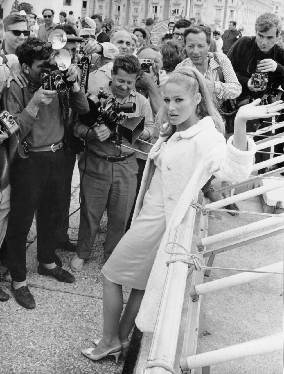 ZUM 80. GEBURTSTAG DER SCHWEIZER FILMSCHAUSPIELERIN URSULA ANDRESS AM SAMSTAG, 19. MAERZ 2016, STELLEN WIR IHNEN FOLGENDES BILDMATERIAL ZUR VERFUEGUNG - Press photographers surround Swiss-born actress Ursula Andress on the Croisette seafront, Cannes, on May 21, 1965, after her arrival to attend the International Film Festival. (AP Photo/Levy)