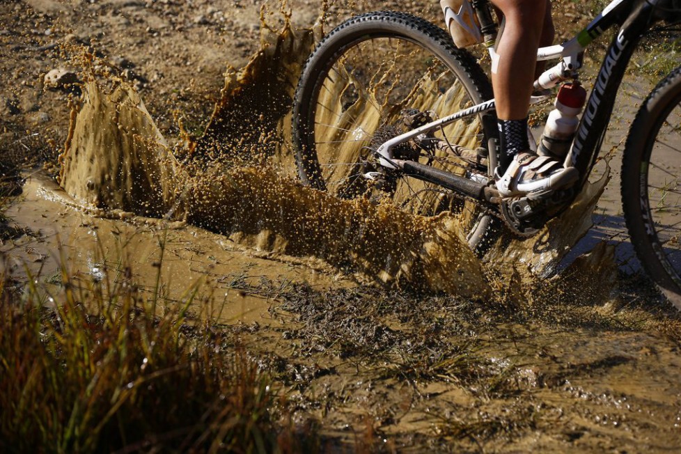 epa04670854 A female rider cycles through mud during the 117km stage five of the Absa Cape Epic mountain bike team stage race in Worcester, South Africa, 20 March 2015. The Absa Cape Epic is considered one of the toughest mountain bike races in the world. The multi stage race sees 1,200 cyclists riding in pairs over 700km and climbing more than 16,000m twice the high of Mount Everest over eight days of racing. EPA/NIC BOTHMA