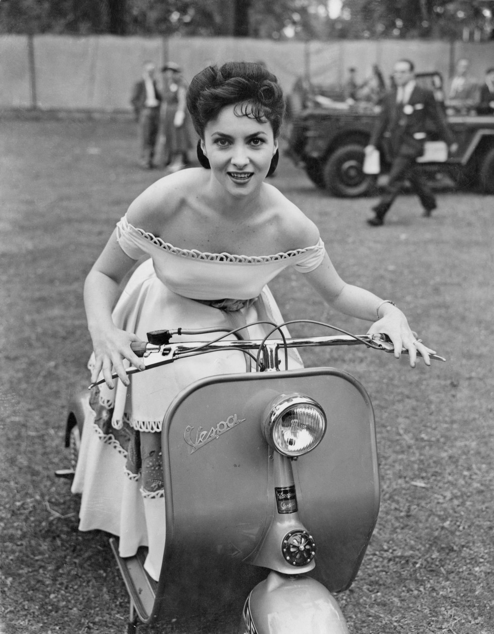 14th June 1952: Italian actress Gina Lollobrigida attends the Great Film Garden Party at Morden Hall Park in Surrey, on a Vespa motor scooter. She is in Britain to promote an Italian Film Festival. (Photo by Ron Case/Keystone/Getty Images)