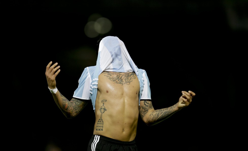 In this Tuesday, March 29, 2016 photo, Argentina's Marcos Rojo pulls his jersey over his head after missing an opportunity to score against Bolivia, during a 2018 World Cup qualifying soccer match, in Cordoba, Argentina. Gabriel Mercado scored in the 19th minute and Lionel Messi made it 2-0 in the 29th on a penalty to lead the Argentines to an easy victory. (AP Photo/Natacha Pisarenko)