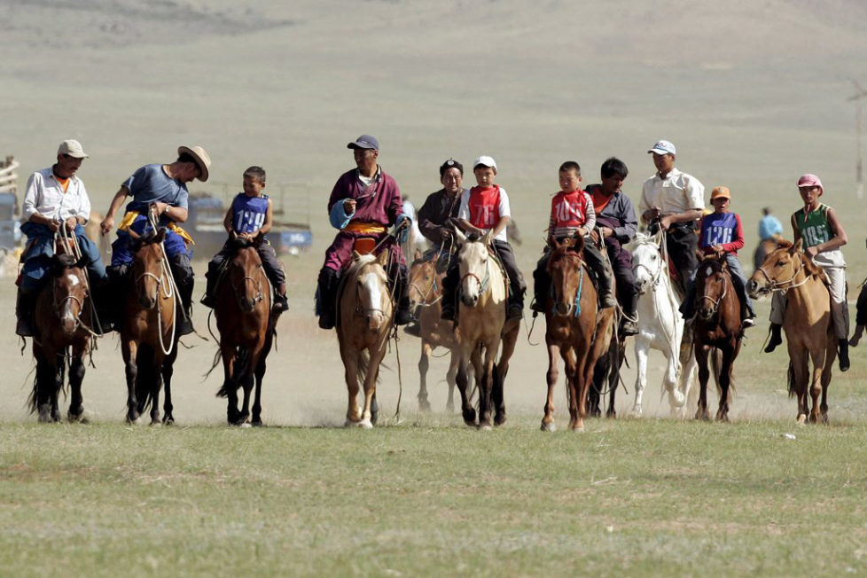 epa01061682 Mongolian children and adults ride to the start of a 23 kilometre horserace jockeyed by children age four to thirteen, in Atar, Tuv Aimag, Mongolia, 10 July 2007. Mongolia is celebrating the Naadam festival from 11-13 July 2007, the most important festival of the year, with horseracing, wrestling and archery - known as the three 'manly sports'. EPA/MICHAEL REYNOLDS
