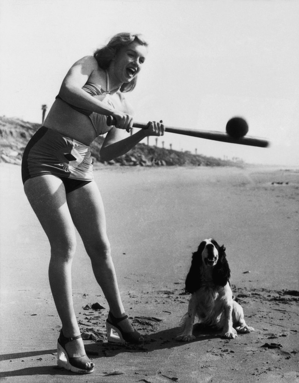 The American actress Marilyn Monroe playing softball in a bathing suit on a beach. USA, 1950s (Photo by Mondadori Portfolio via Getty Images)