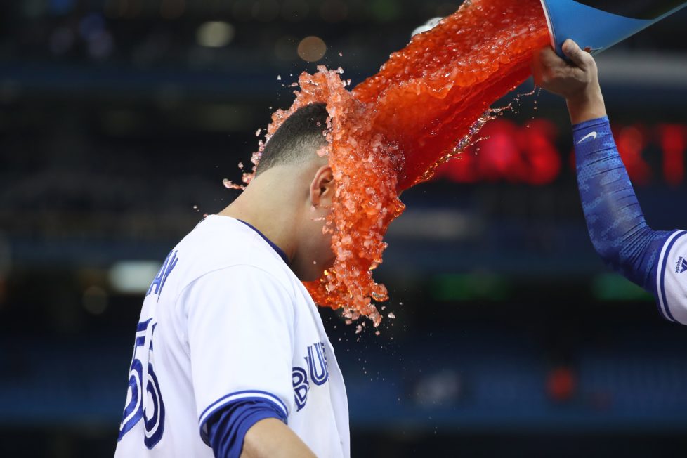 TORONTO, CANADA - MAY 4: Russell Martin #55 of the Toronto Blue Jays has Gatorade dumped on him by Darwin Barney #18 after hitting a game-winning RBI single during MLB game action against the Texas Rangers on May 4, 2016 at Rogers Centre in Toronto, Ontario, Canada. (Photo by Tom Szczerbowski/Getty Images) *** BESTPIX ***