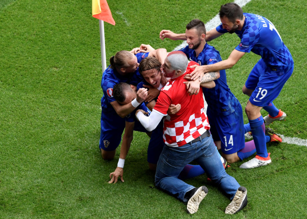 A fan enters onto the pitch to celebrates with Croatia's midfielder Luka Modric and his teammates after Modric scored the team's first goal during the Euro 2016 group D football match between Turkey and Croatia at Parc des Princes in Paris on June 12, 2016. / AFP PHOTO / PHILIPPE LOPEZ