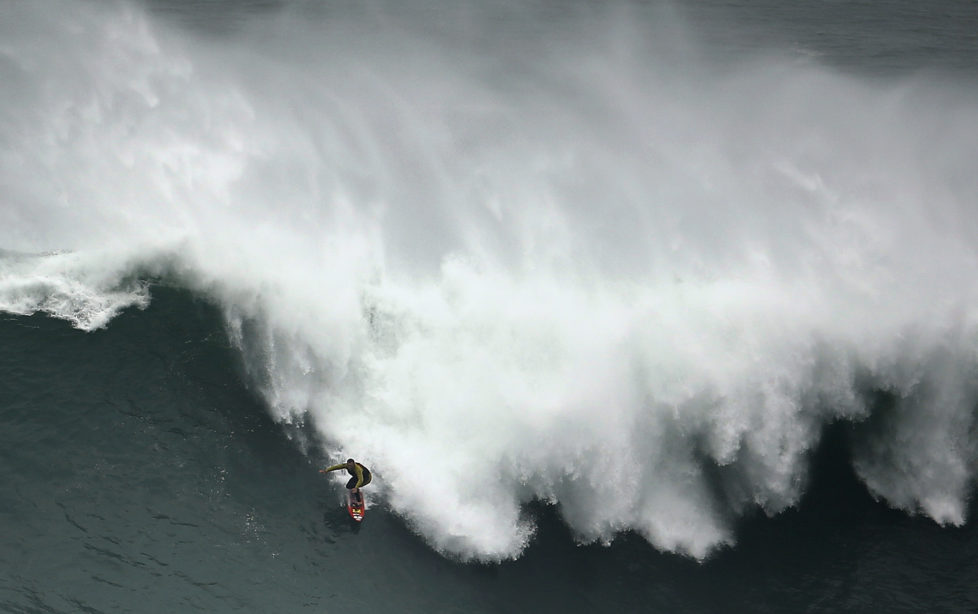 Big-wave surfer Garrett McNamara of the U.S. drops in on a large wave at Praia do Norte, in Nazare November 1, 2013. McNamara, who lives in Haleiwa, Hawaii, won the Biggest Wave title at the 2012 Billabong XXL Big Wave Awards with his world record 78-foot (24-metre) wave ridden at Praia do Norte, Nazare, Portugal on November 1, 2011. McNamara has returned to Nazare because he wants to try to beat the record again. REUTERS/Rafael Marchante (PORTUGAL - Tags: SPORT TPX IMAGES OF THE DAY) - RTX14WO2